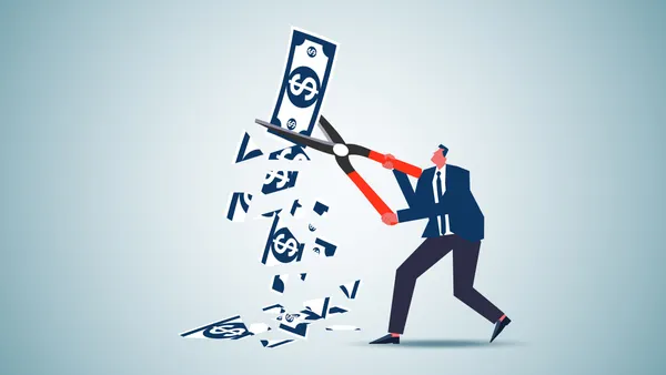 Business person cutting a dollar bill to represent controller salaries plummeting.