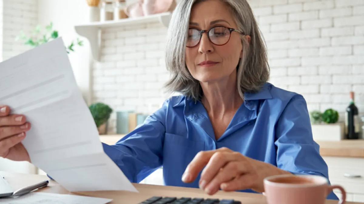 Senior mature business woman holding paper