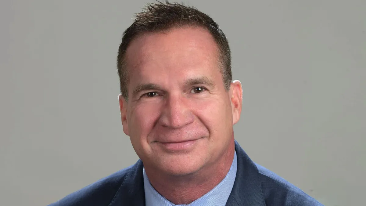 A portrait of a person dressed in business attire.