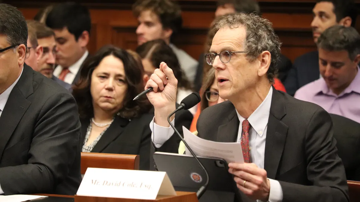 David Cole reads from a paper while testifying.