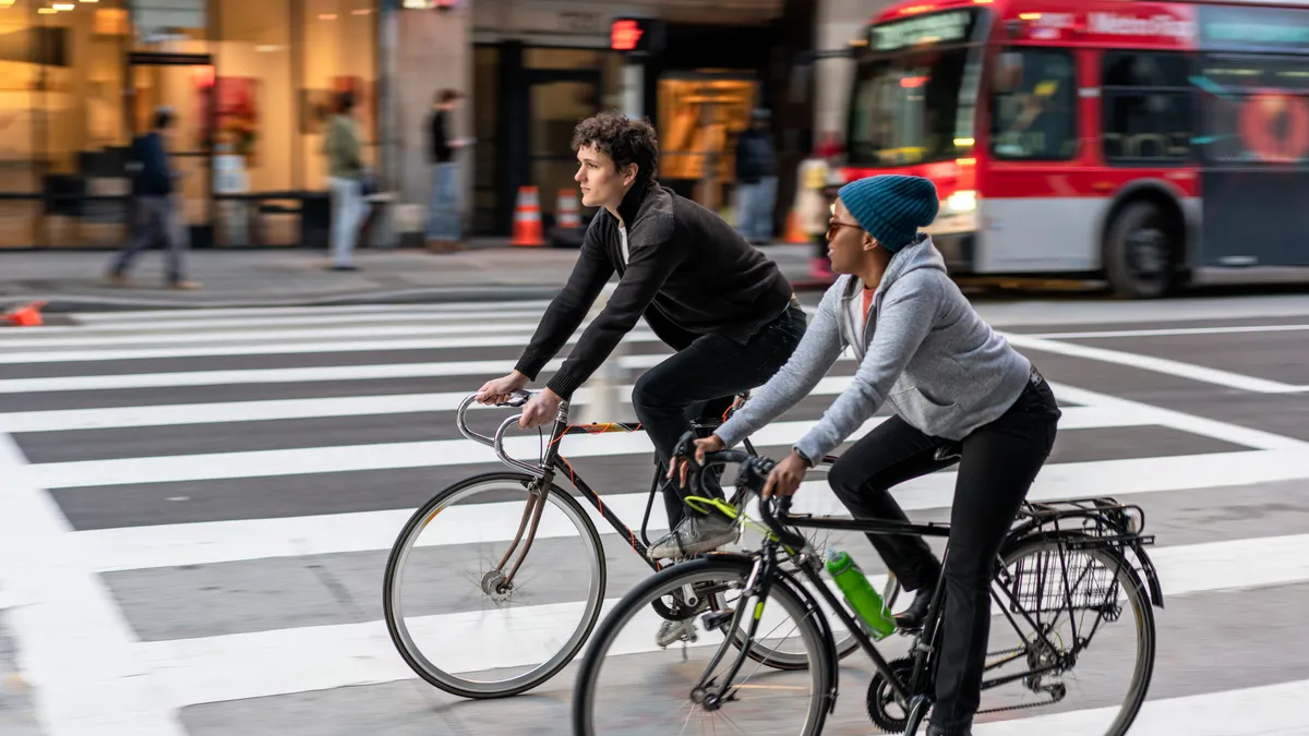 Two friends cycling together in downtown Los Angeles.