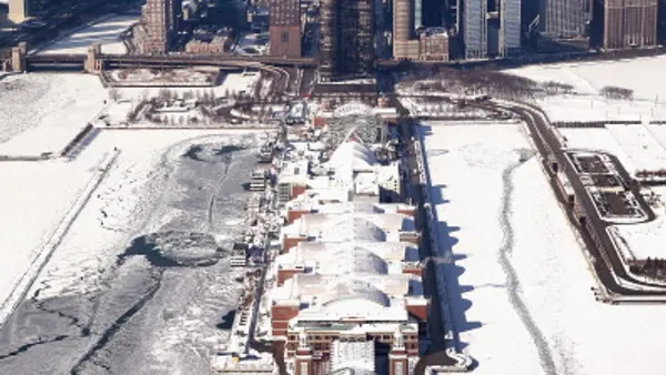 aerial photo of Chicago's Navy pier during the winter extending into frozen lake in forefront with skyline in background