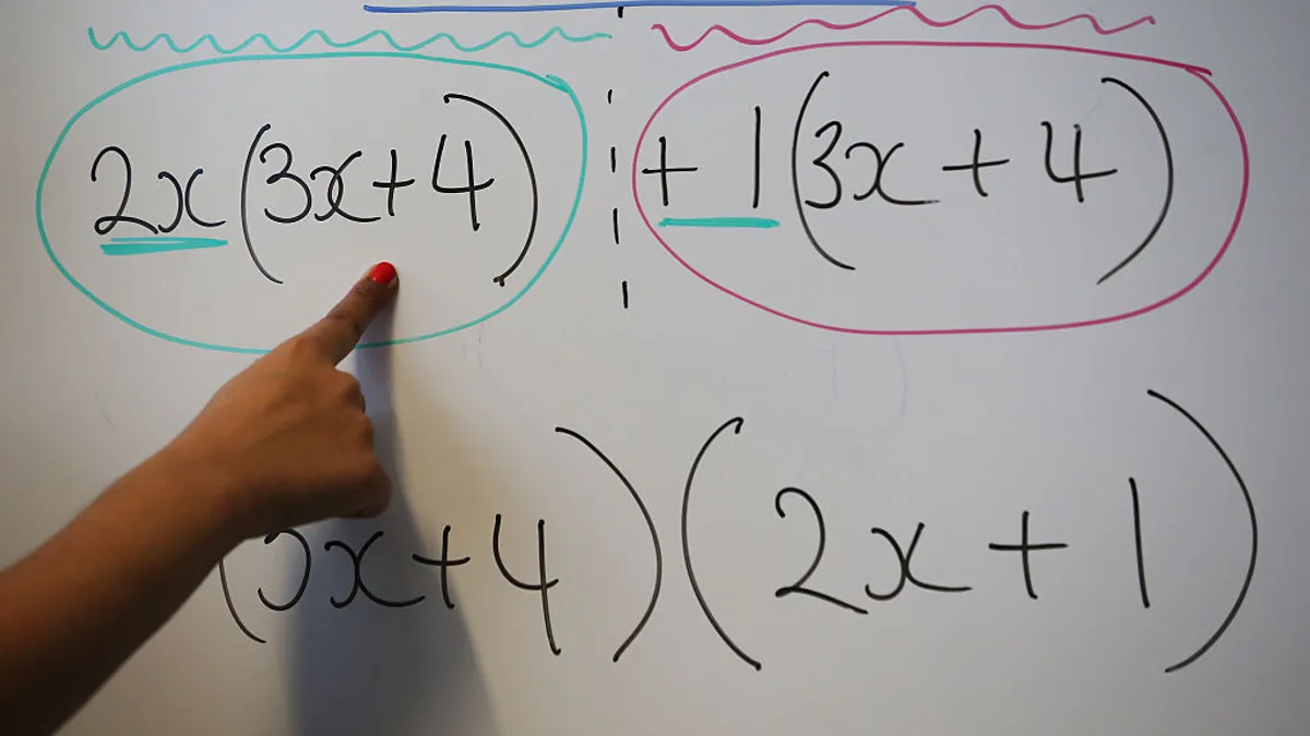 A person's hand is shown pointing to algebraic equations on a whiteboard, illustrating mathematical processes to unseen onlookers.