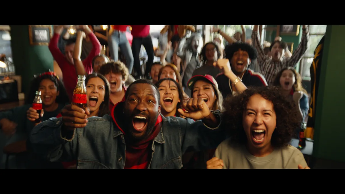 A group of college football fans scream at a bard in an ad for Coke Zero Sugar.