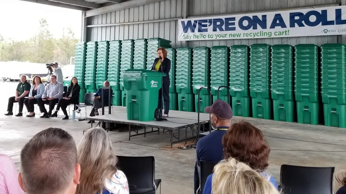 CVWMA Executive Director Kim Hynes speaks in front of recycling carts