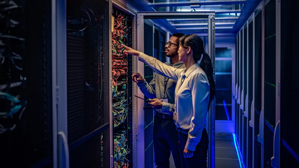 IT engineers checking servers in server room.