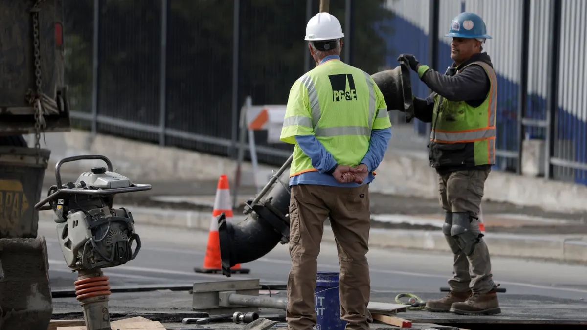 Workers make repairs to an underground pipe