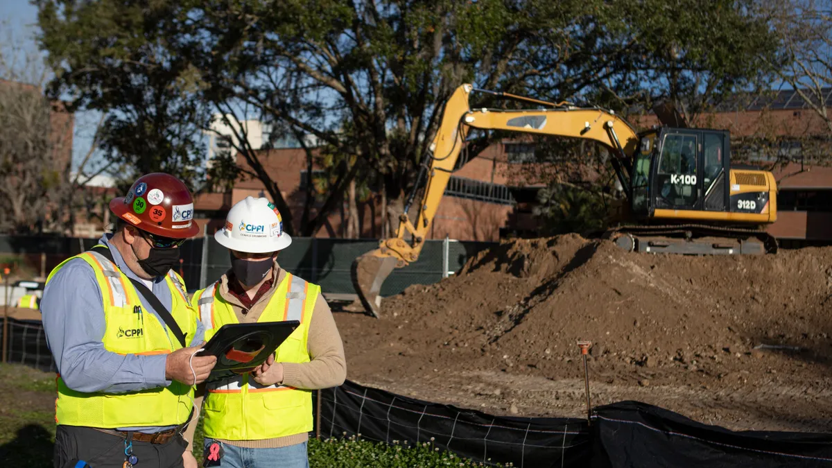 People using a tablet at construction site