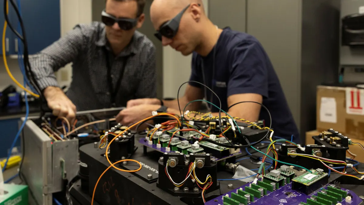 Two people working on a complex computer system