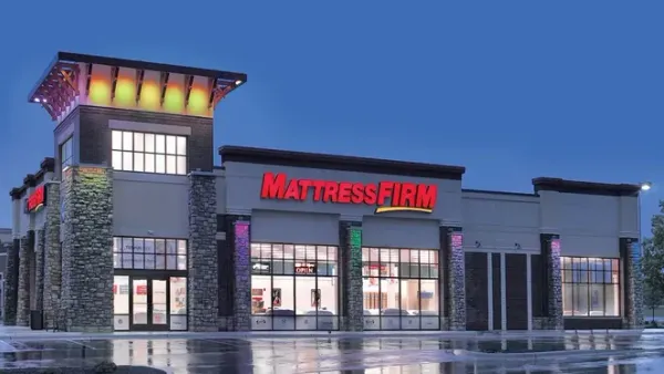An illuminated Mattress Firm storefront at night.