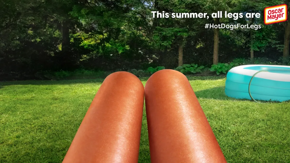 Two hotdogs meant to look like legs in front of an inflatable pool.