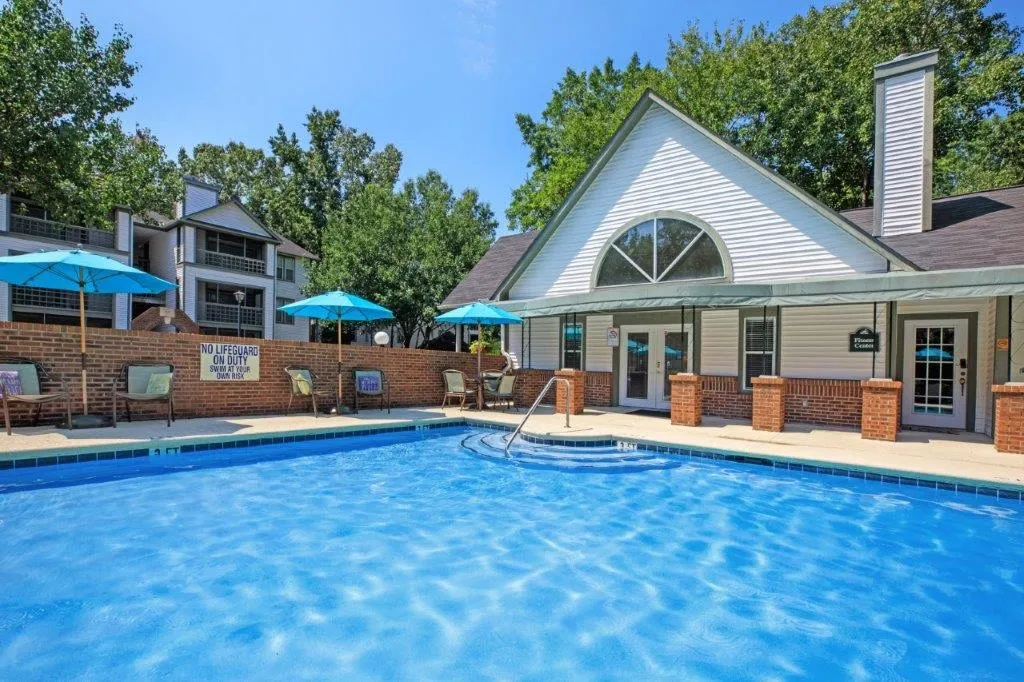 Pool with apartments and clubhouse in the background.