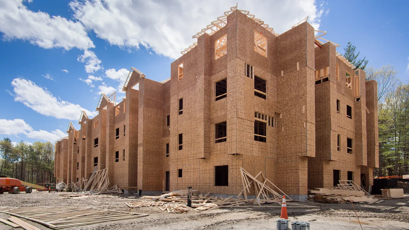 Wood-framed apartment building under construction.