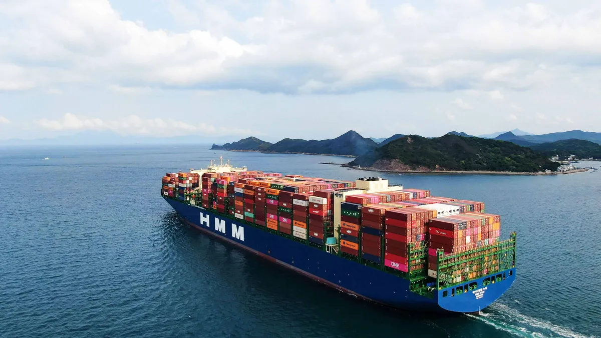 A containership full of containers sails along the ocean.