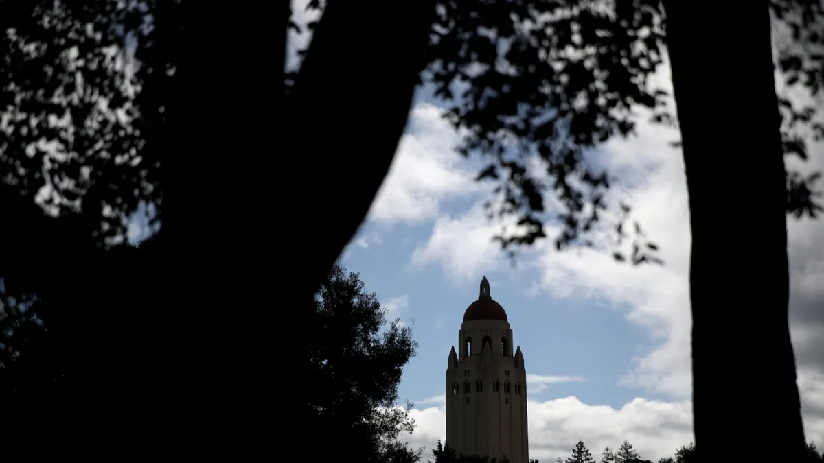 A tower can be seen through trees.