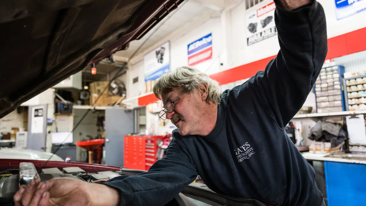 A mechanic checks an automobile's oil.
