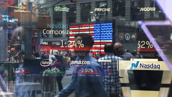 Stock prices are seen on a window reflection.