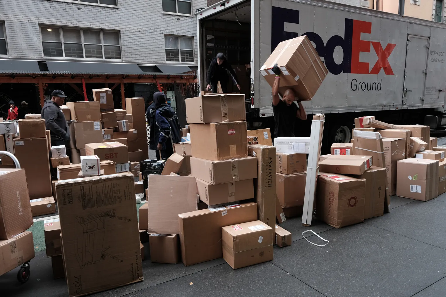 Dozens of packages are lined up along a Manhattan street as a FedEx truck makes deliveries on December 6, 2021 in New York City.