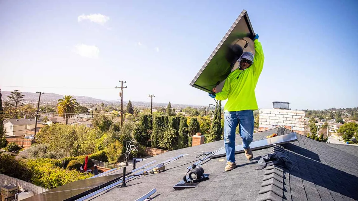 A team of workers installing solar panels on a home in California.