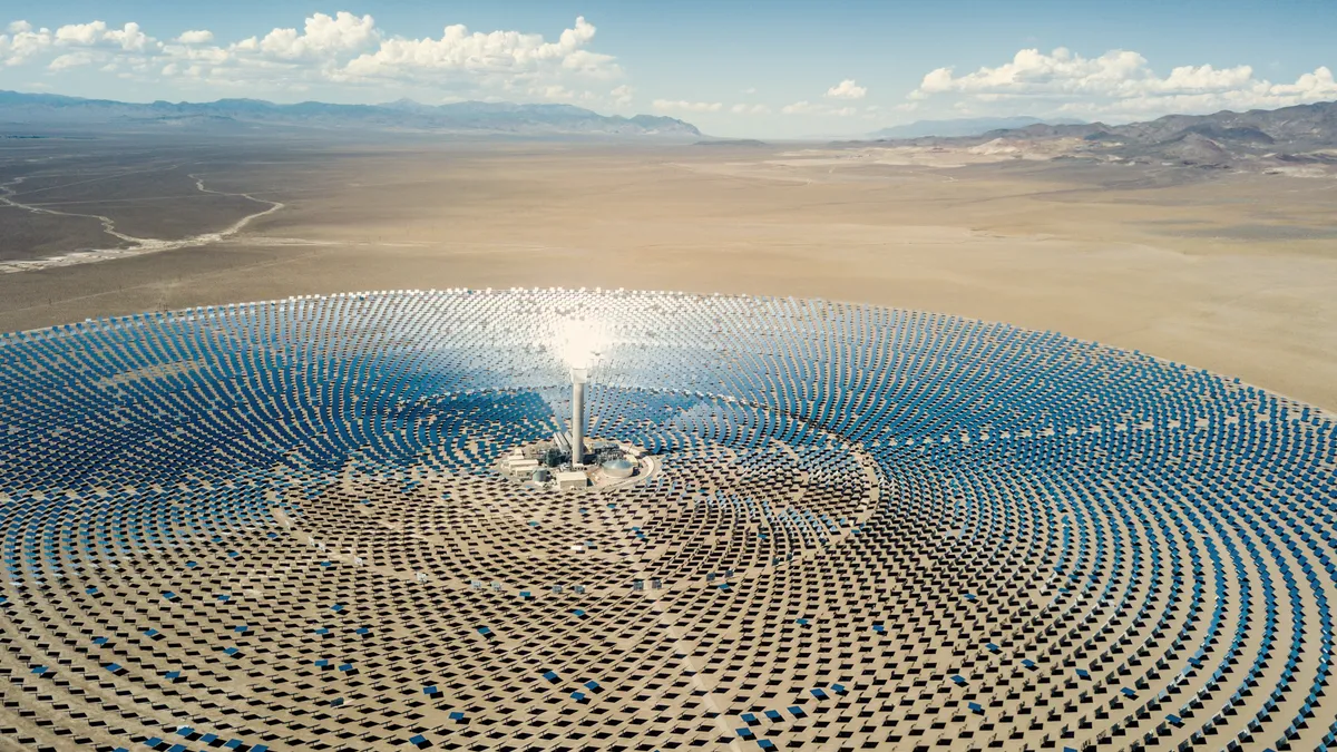 Aerial view from a drone down to large solar thermal power station in the dry desert landscape to the horizon. Nevada, USA.