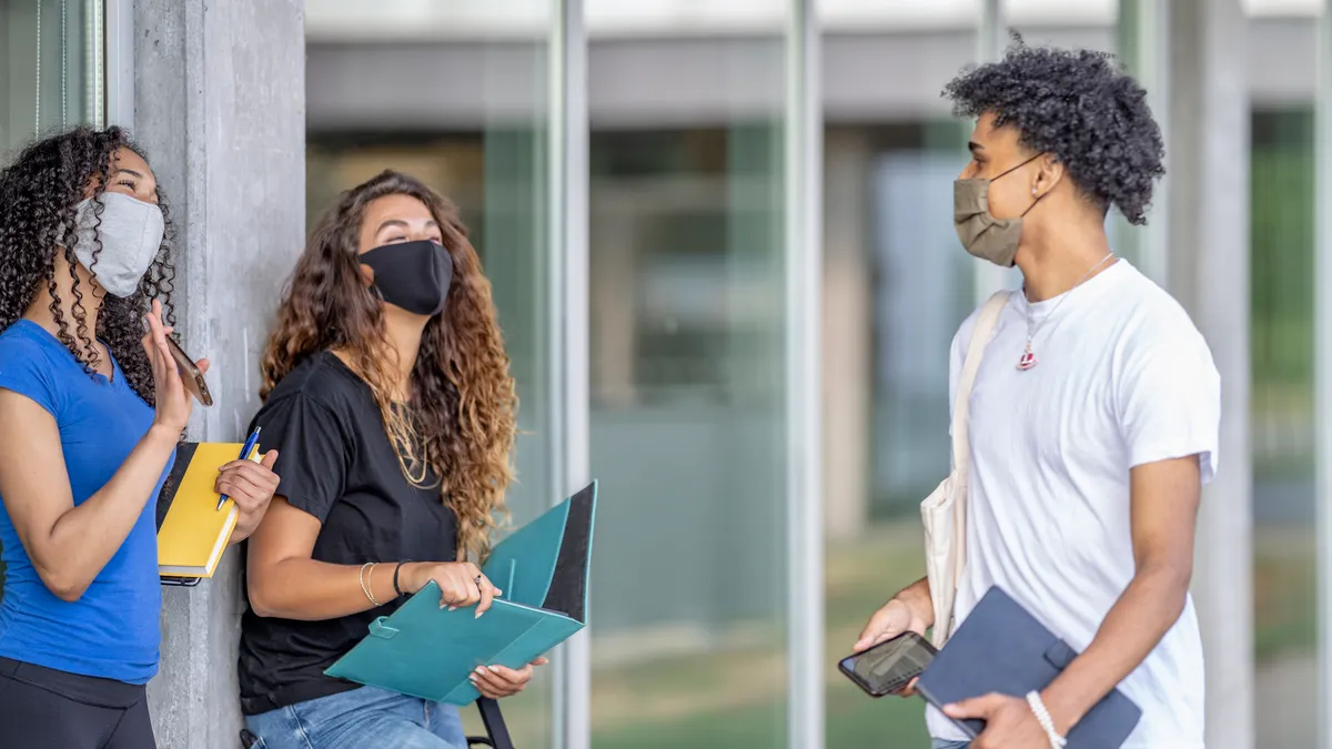 college students walking on campus wearing facemasks