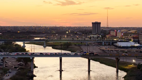 A view of the Rio Grande at sunset, showing traffic and bridges.