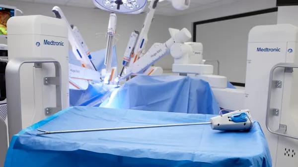 A surgical instrument lies on a table covered in a blue drape.