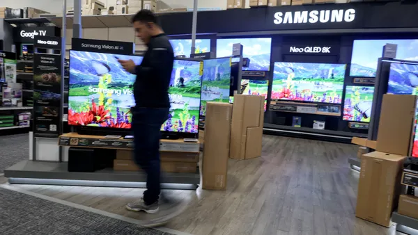 A person walks in front of a Samsung display of products.