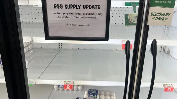 An egg display case is seen with a sign saying that supply shortages may impact product availability