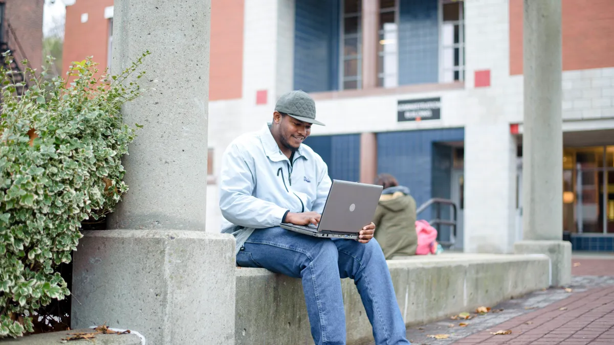 Roxbury Community college student sitting on campus