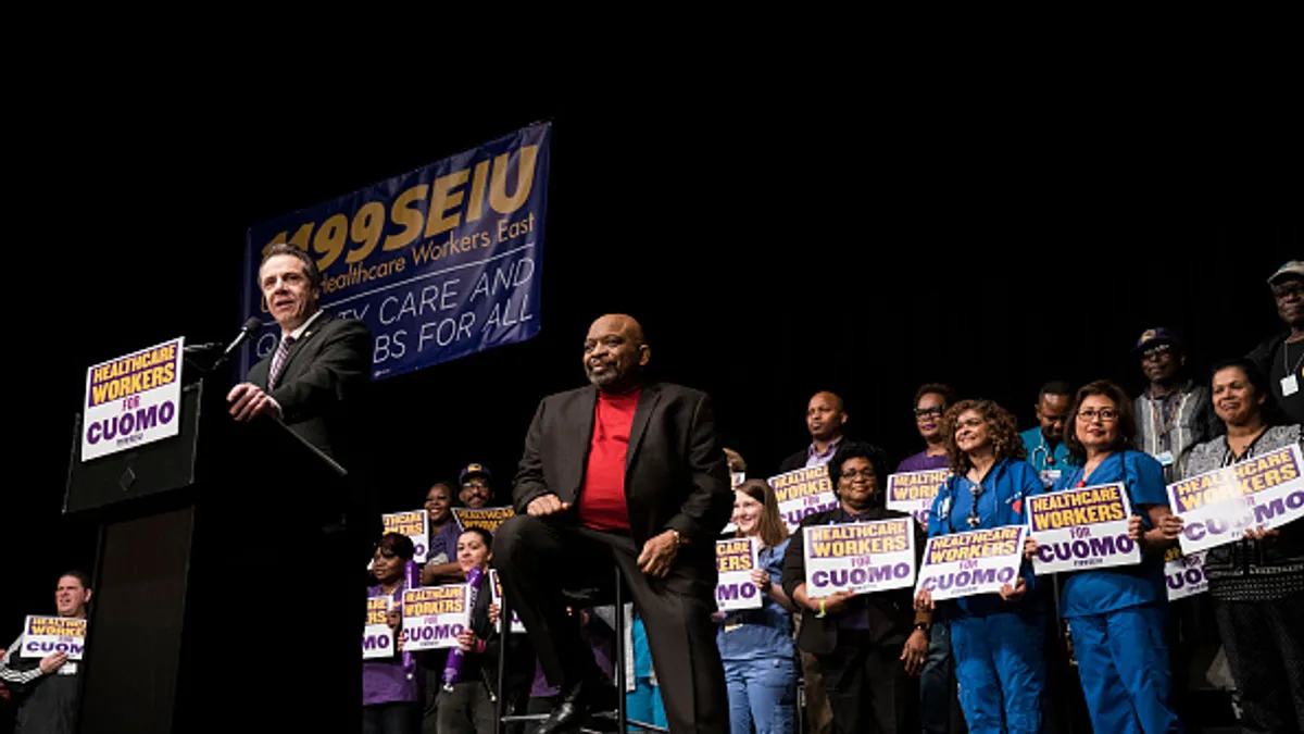 New York Governor Andrew Cuomo speaks as 1199SEIU United Healthcare Workers East President George Gresham looks on at a healthcare union rally at the Theater at Madison Square Garden, February 21, 2018 in New York City. The rally was organized by 1199SEIU United Healthcare Workers East, the largest healthcare union in the United States.