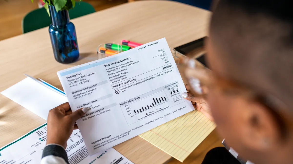 A young woman looks at the electricity bill