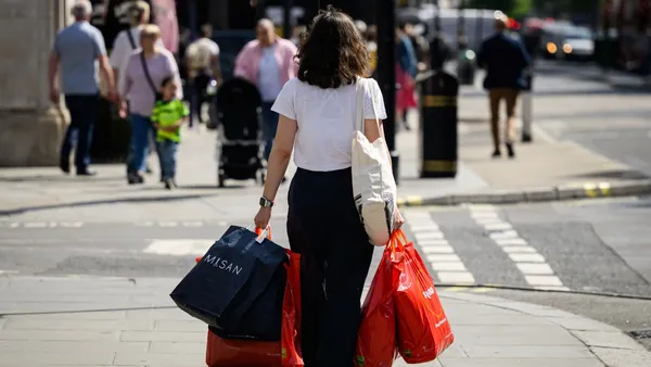 A shopper holds multiple shopping bags.