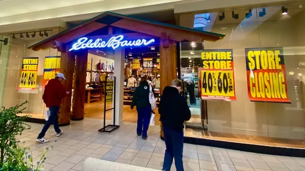 People walking into an Eddie Bauer that is going out of business.