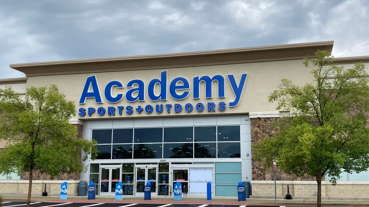 A retail storefront. The storefront sign reads "Academy Sports + Outdoors