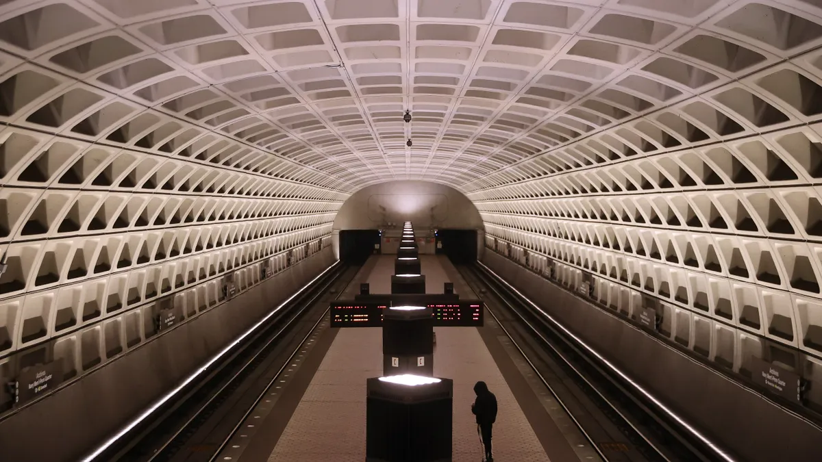 A single rider waits on a train platform at a Washington Metro rail station.