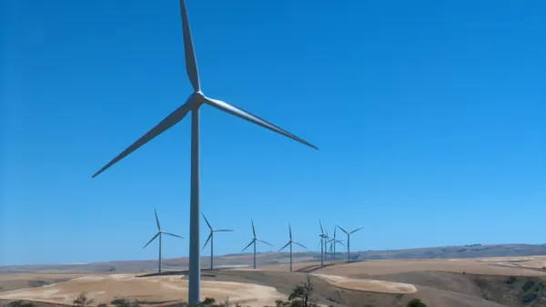 A wind farm near a parched field.