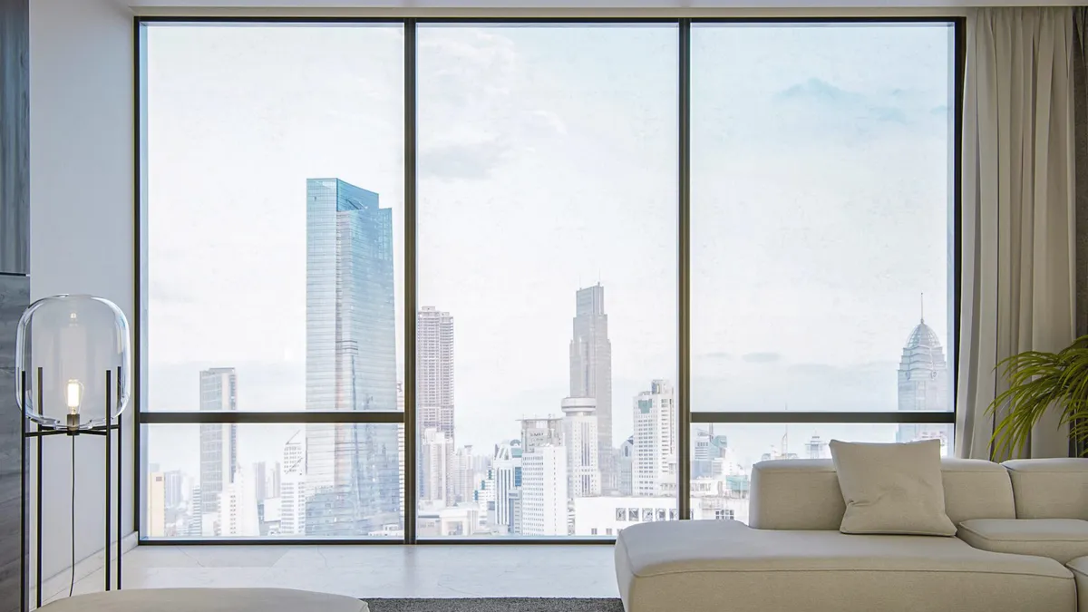 A living room with a window overlooking a city.