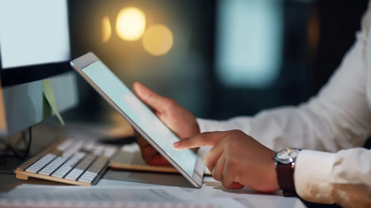 A businessperson using a digital tablet during a late night in a modern office