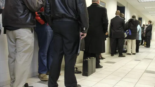 People wait in line to attend a job fair.