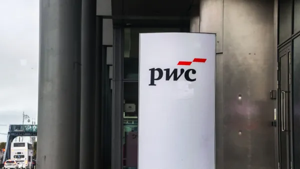 A signpost with the PwC corporate logo pictured outside a building.