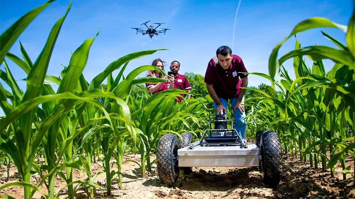 Mississippi State University Assistant Professor Hussein Gharakhani assesses the performance of an autonomous agricultural robot in the field.