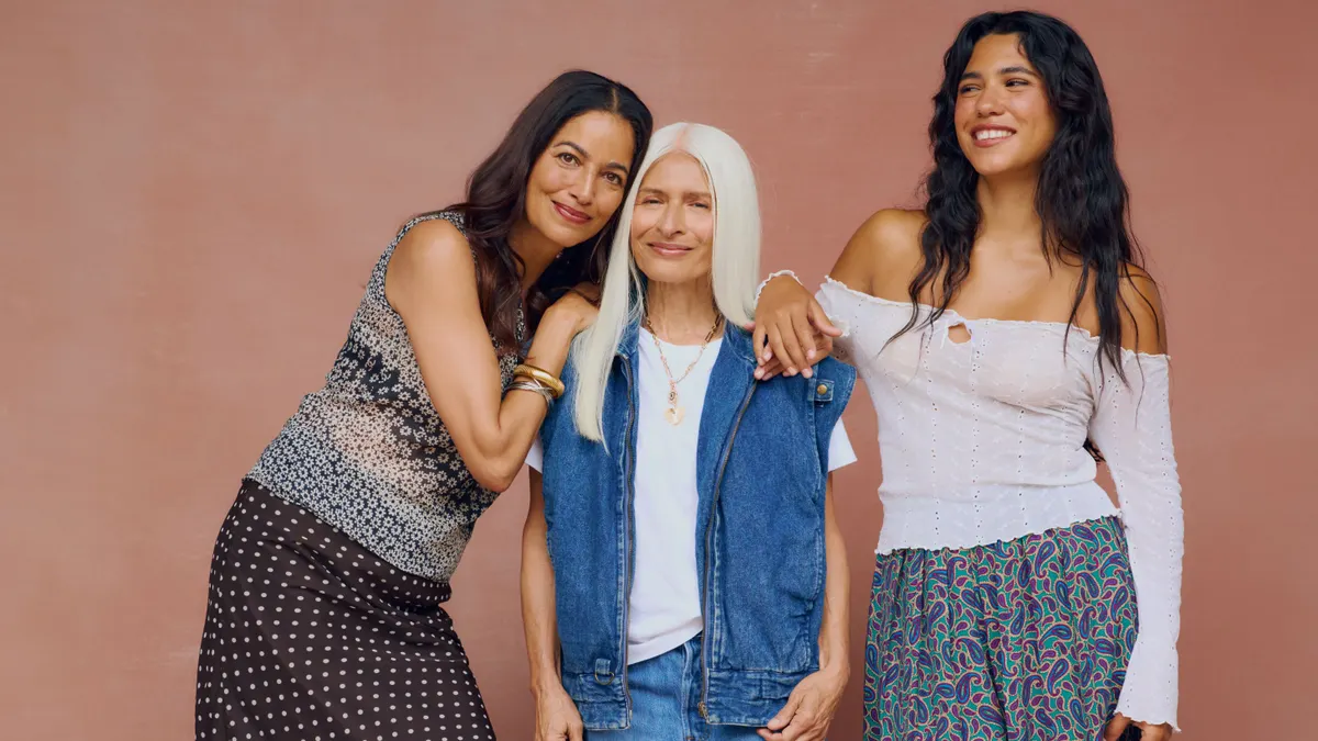 Three women pose while wearing vintage clothing.