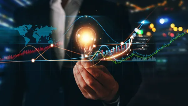 A person's hand holding a lightbulb.