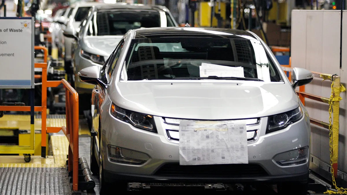 Silver Chevy Volt electric vehicles and Opel Amperas come off an assembly line.