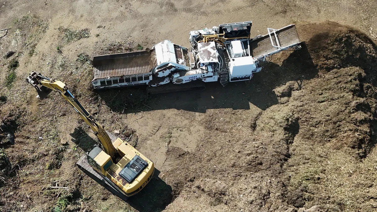 An aerial view of construction vehicles moving materials on a work site