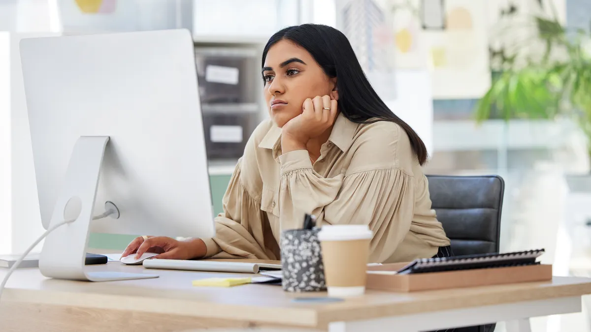Tired employee working on a computer in the office leaning