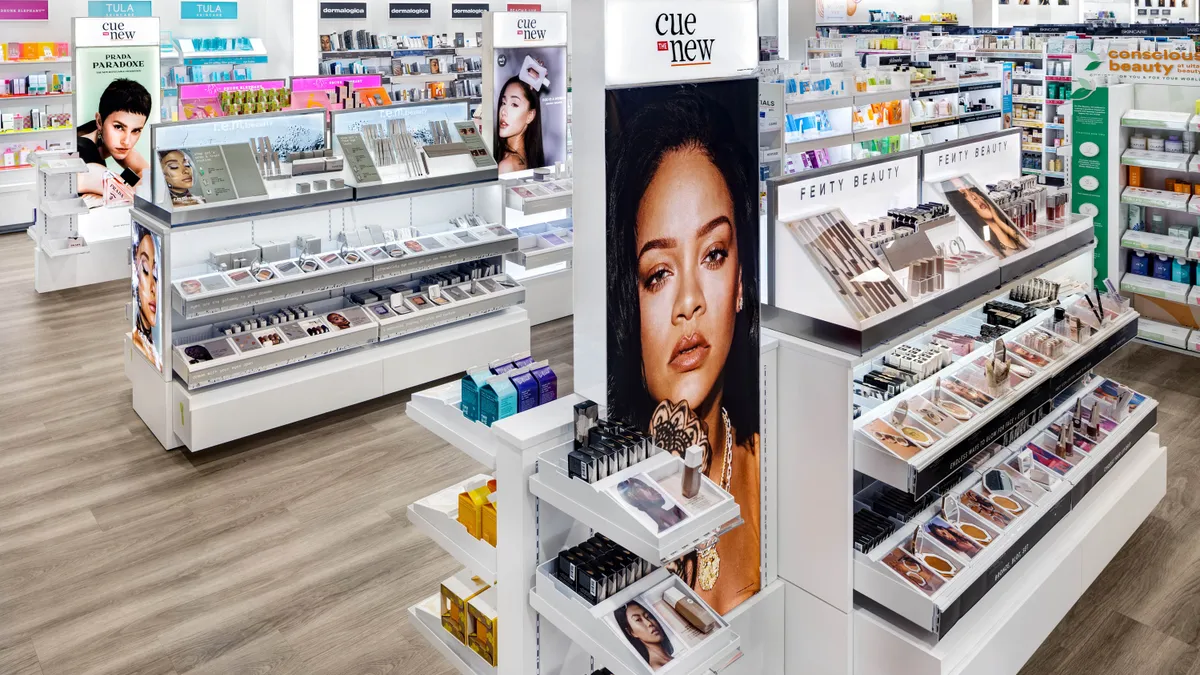 Orange and white Ulta store display saying "Cue the New"