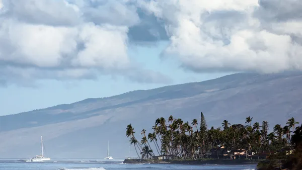A surfer rides a wave in the distance
