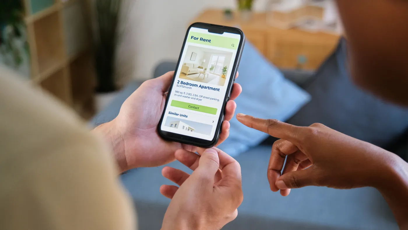 Hands holding a phone looking at rented property